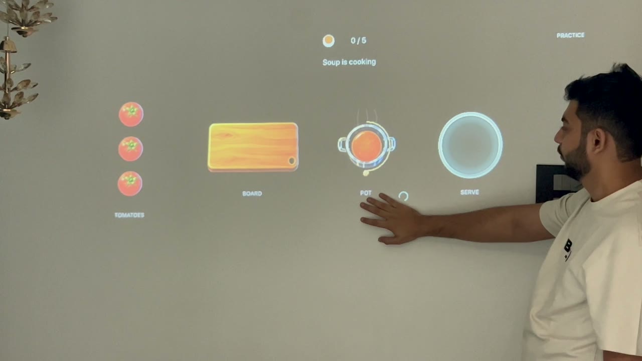 A player using an open hand to interact with a soup pot in Playfield’s projected Counter Crew kitchen